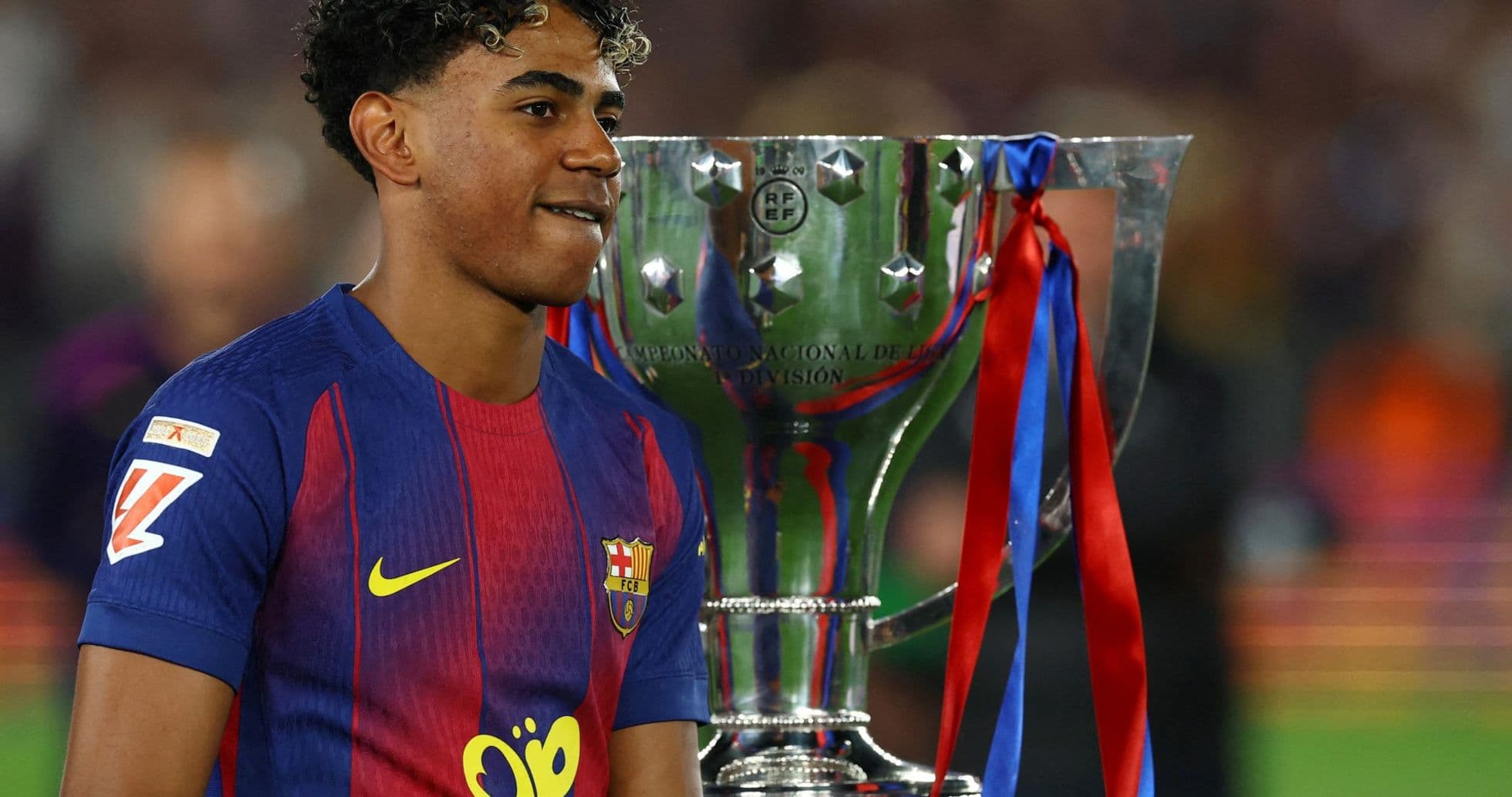Jugador del Barcelona junto al trofeo de campeón