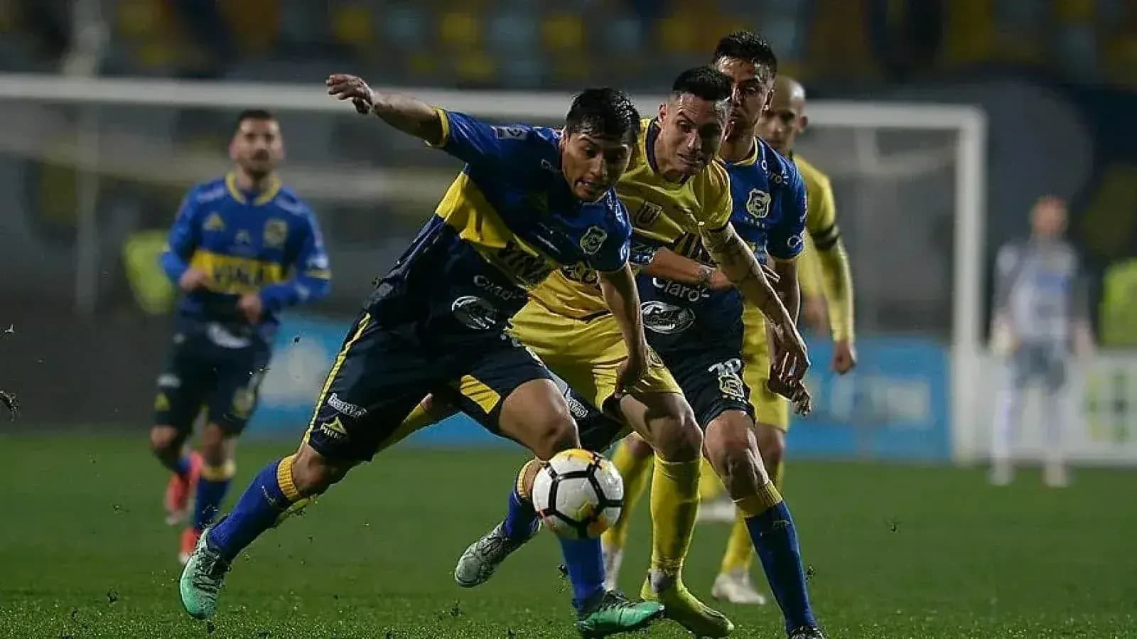 Jugadores compitiendo por el balón en partido