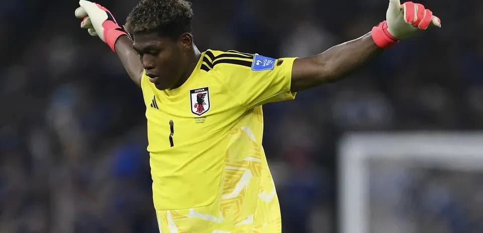 Portero japonés levantando los brazos en el partido