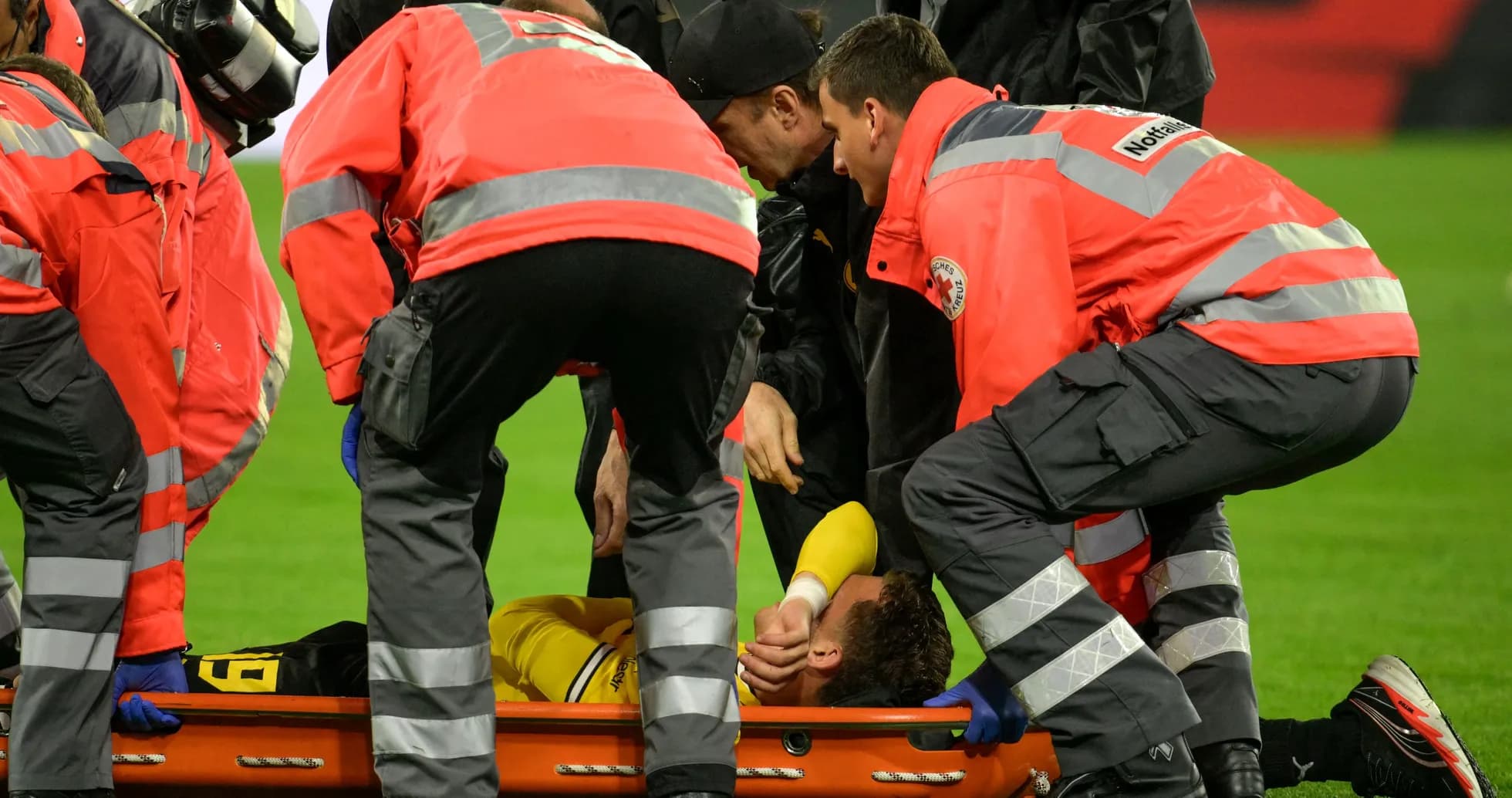 Personal médico atendiendo a jugador lesionado en el campo