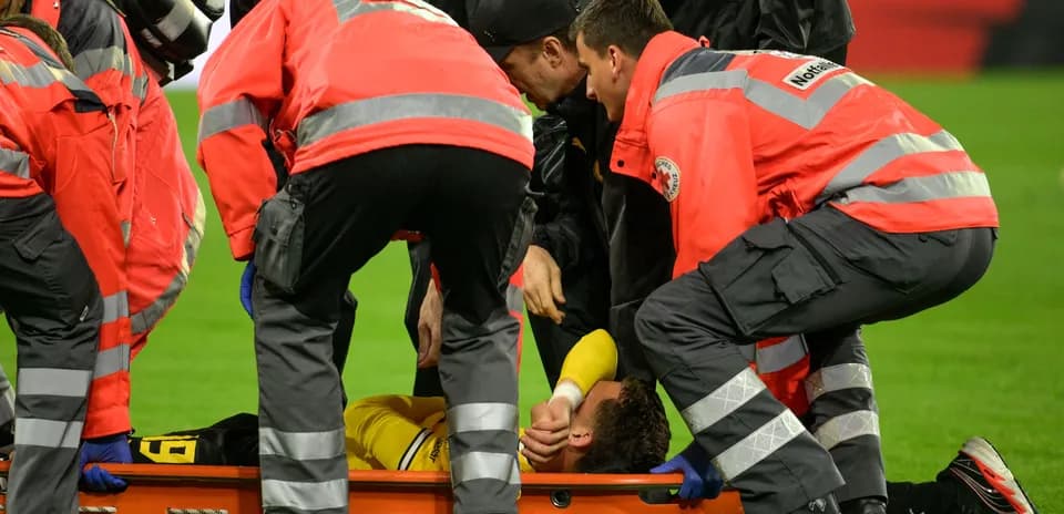Personal médico atendiendo a jugador lesionado en el campo