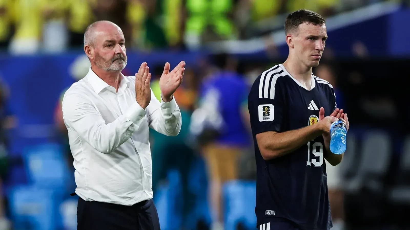 Entrenador aplaudiendo junto a jugador tras partido