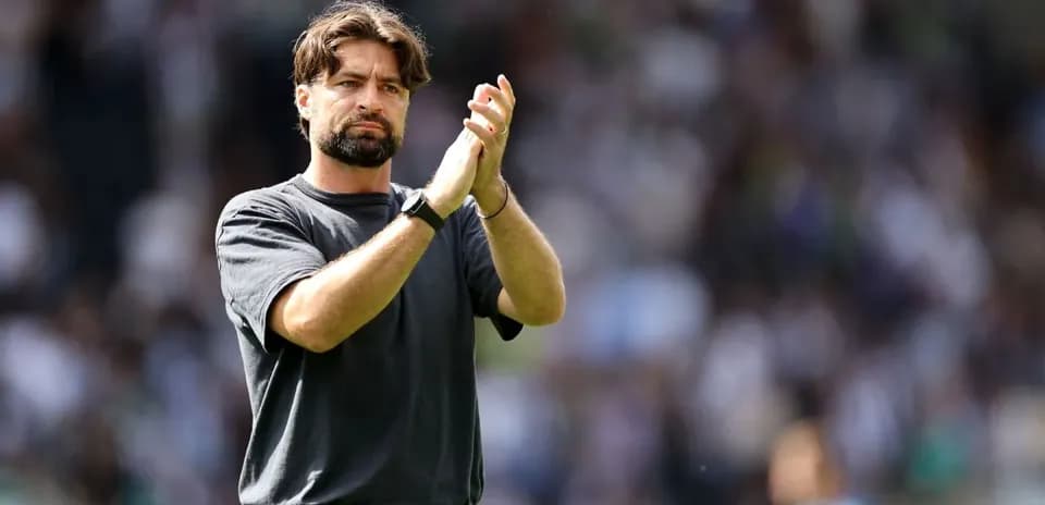 Entrenador aplaudiendo a la afición en el estadio