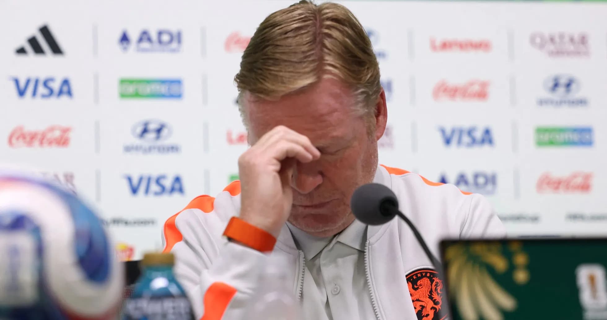 Entrenador en conferencia de prensa, con la cabeza agachada