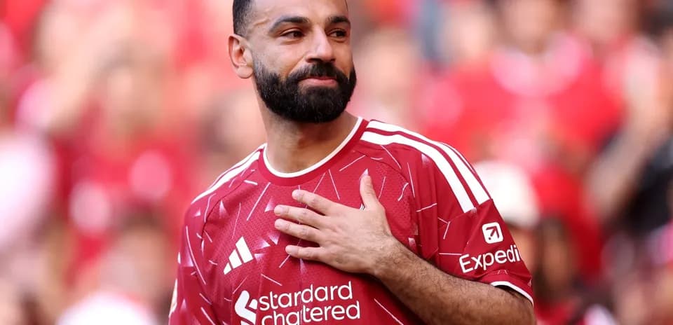 Jugador con camiseta roja saludando a la multitud