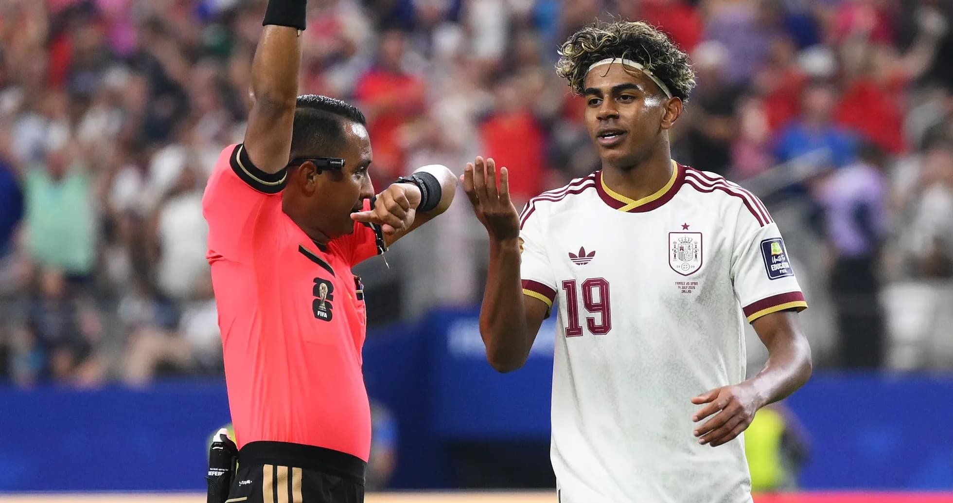 Árbitro mostrando tarjeta mientras jugador se queja