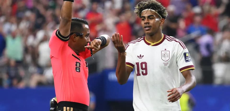 Árbitro mostrando tarjeta mientras jugador se queja