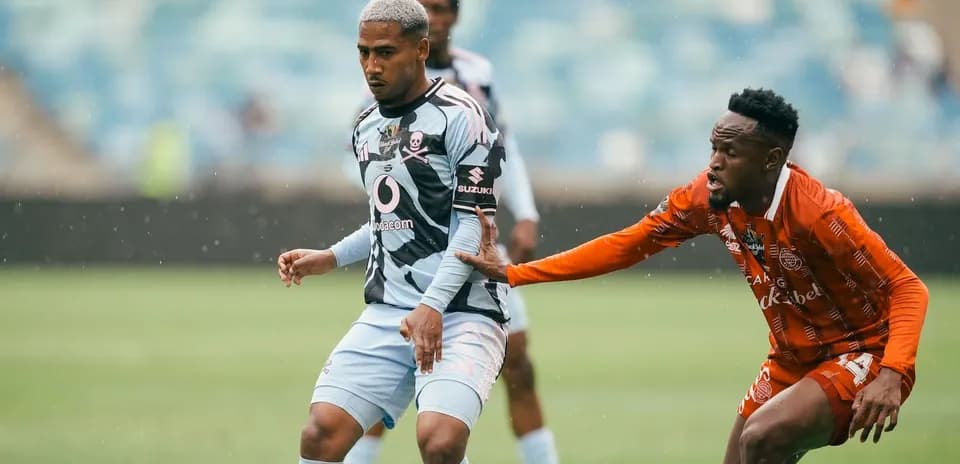 Jugador evadiendo a oponente durante un partido de fútbol