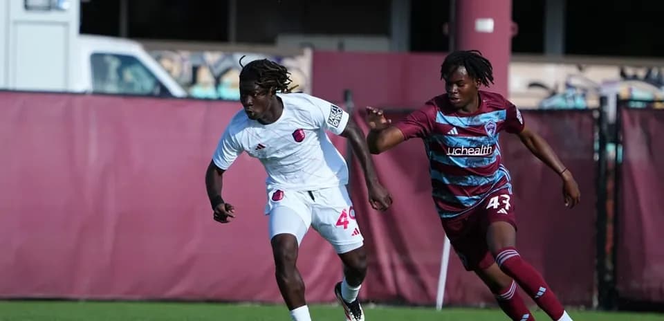 Dos jugadores corriendo por el balón en el partido