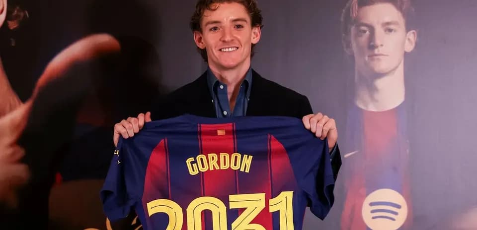 Jugador sosteniendo camiseta del FC Barcelona en presentación