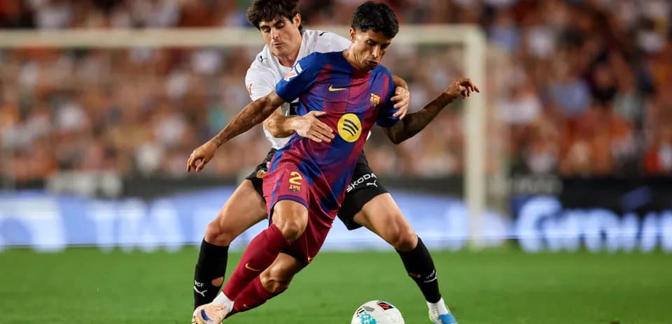 Jugador de Barcelona siendo desafiado por rival