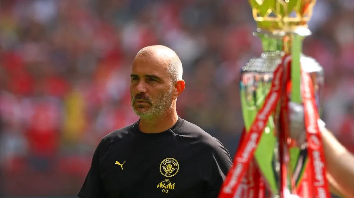Entrenador de Manchester City junto a trofeo de liga