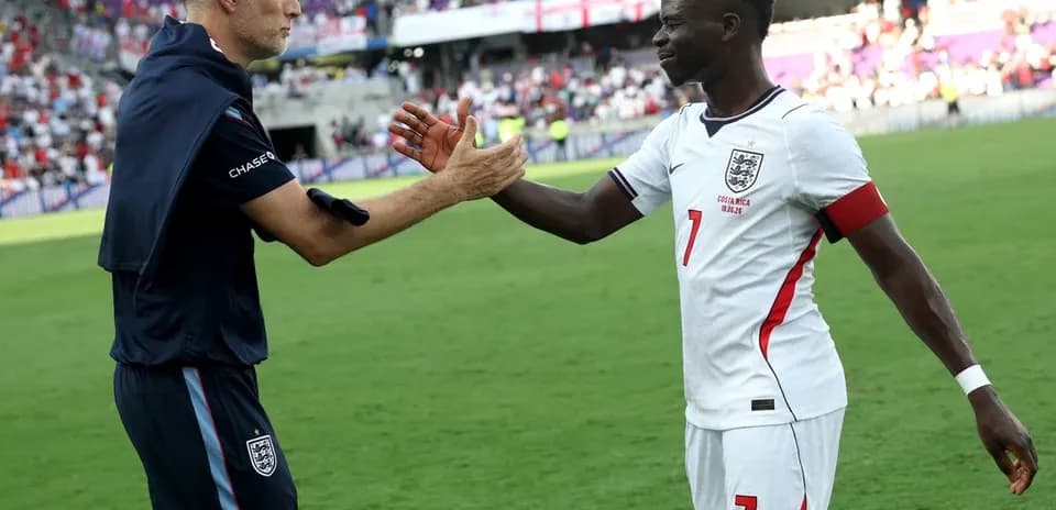 Entrenador y jugador de Inglaterra saludando en el campo