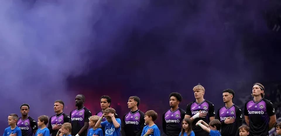 Jugadores y niños de pie durante ceremonia previa al partido