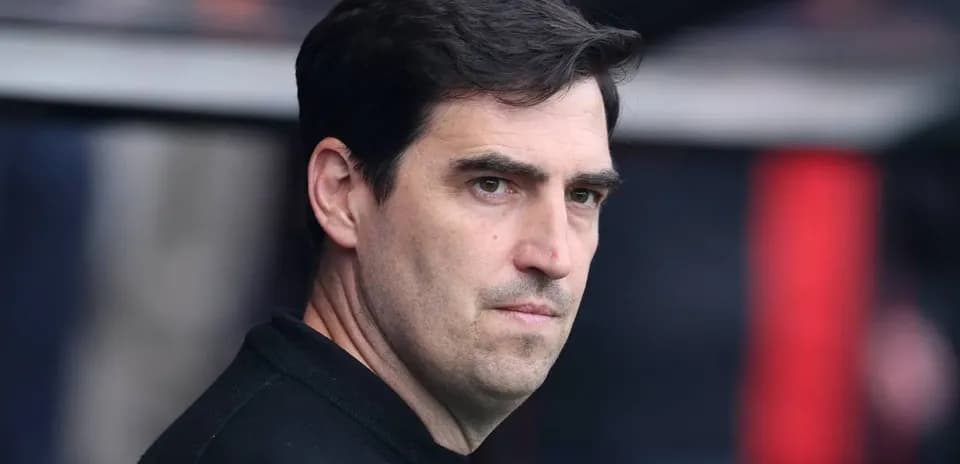 Entrenador observando desde el banquillo del estadio