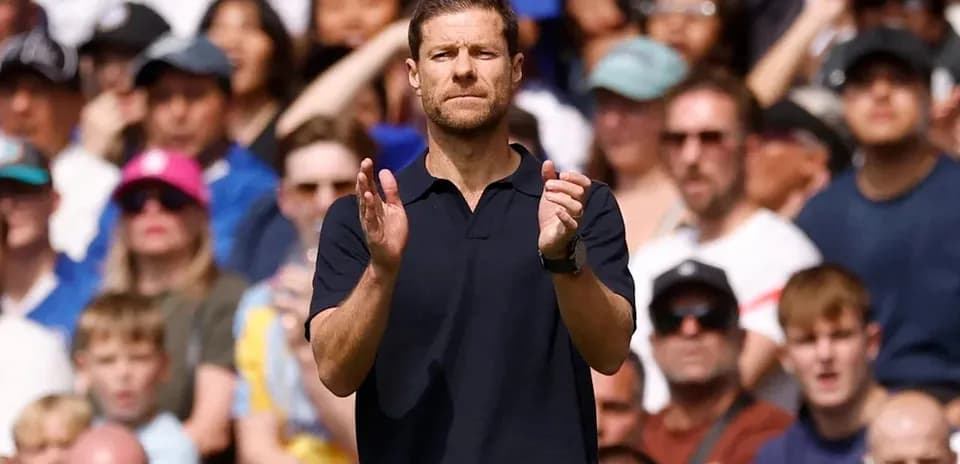 Entrenador aplaudiendo frente a la multitud durante el partido