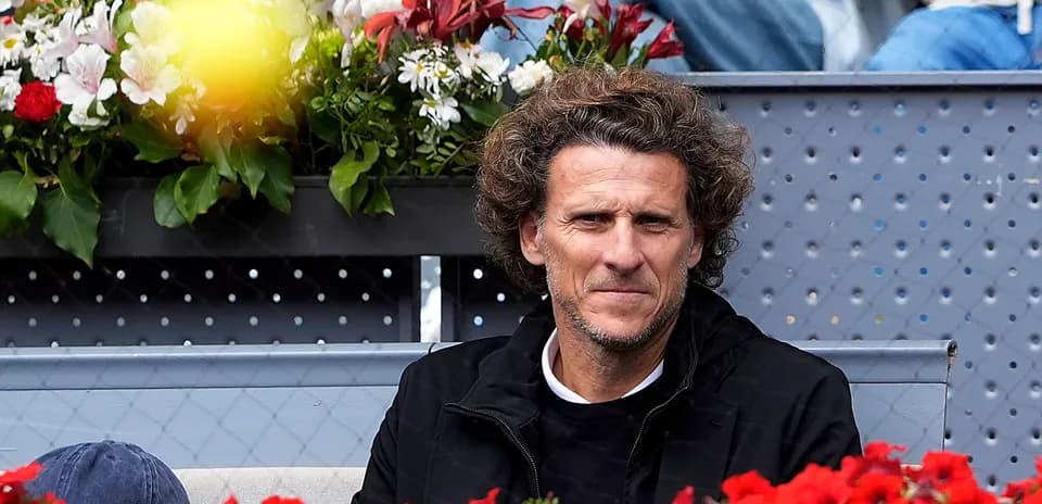 Hombre sentado entre flores en un evento de tenis