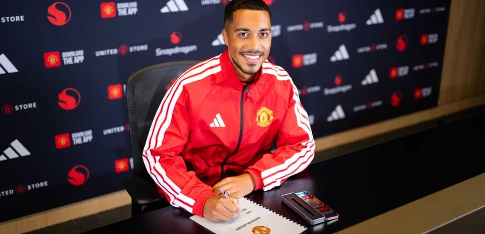 Jugador firmando contrato en mesa de presentación
