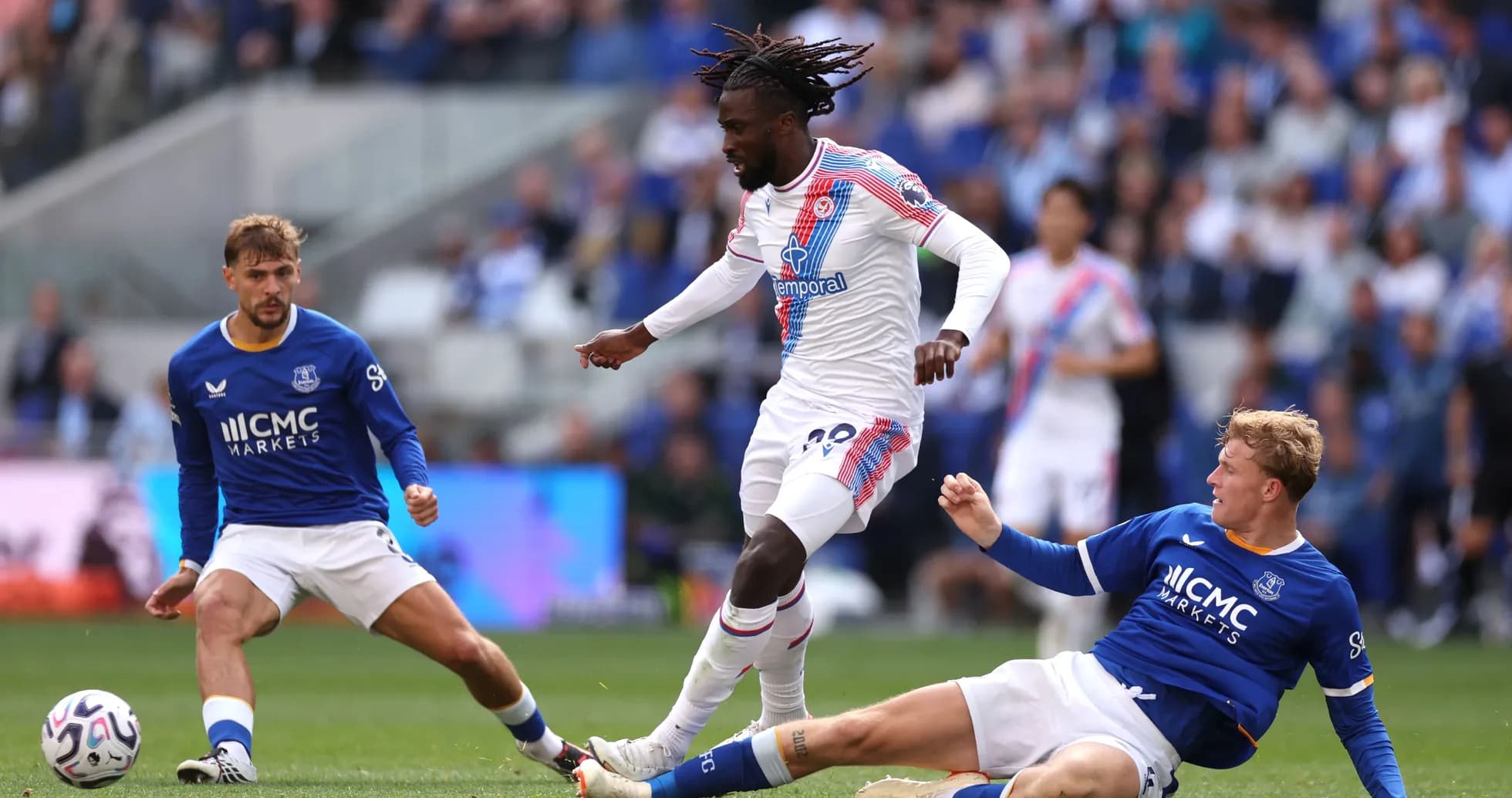 Jugador de Crystal Palace esquivando a dos rivales de Everton