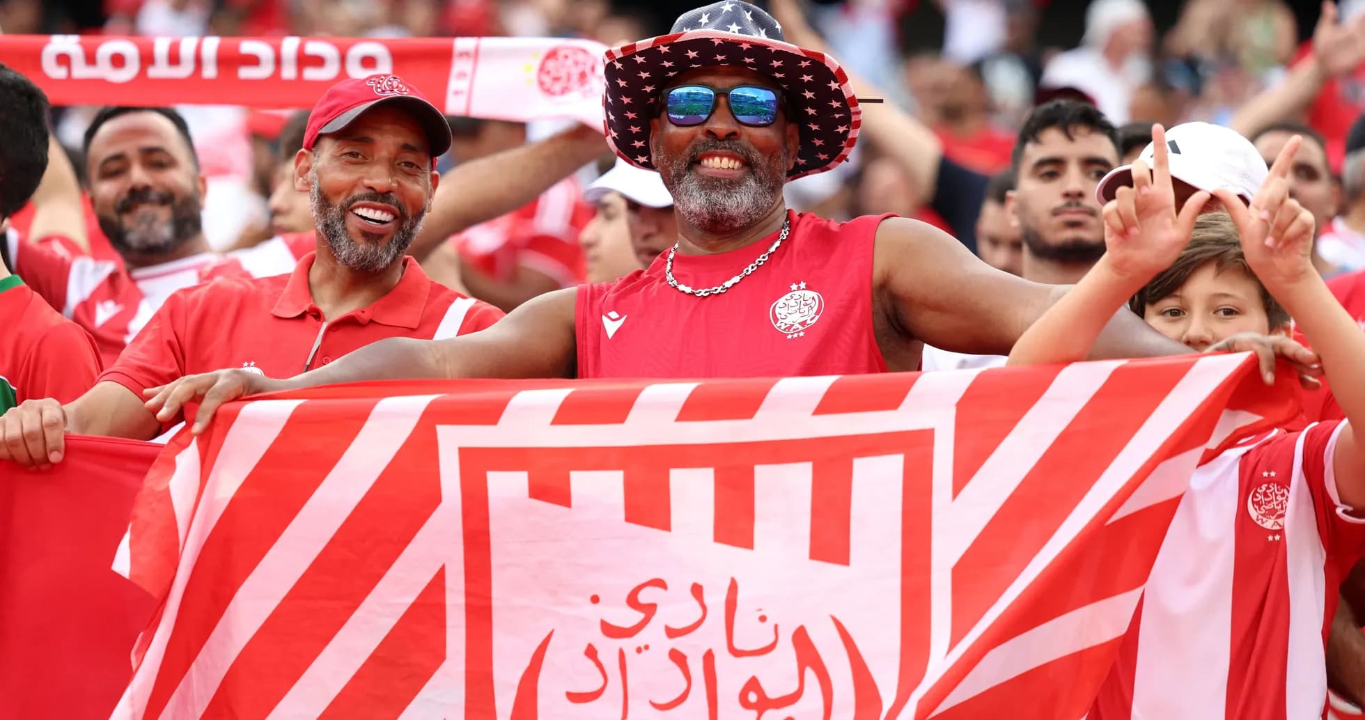 Aficionados de Wydad Casablanca sosteniendo una bandera