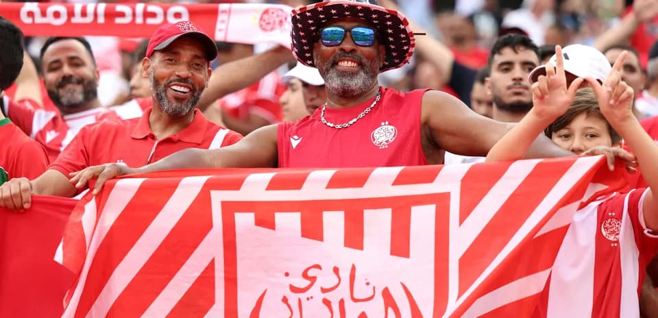 Aficionados de Wydad Casablanca sosteniendo una bandera