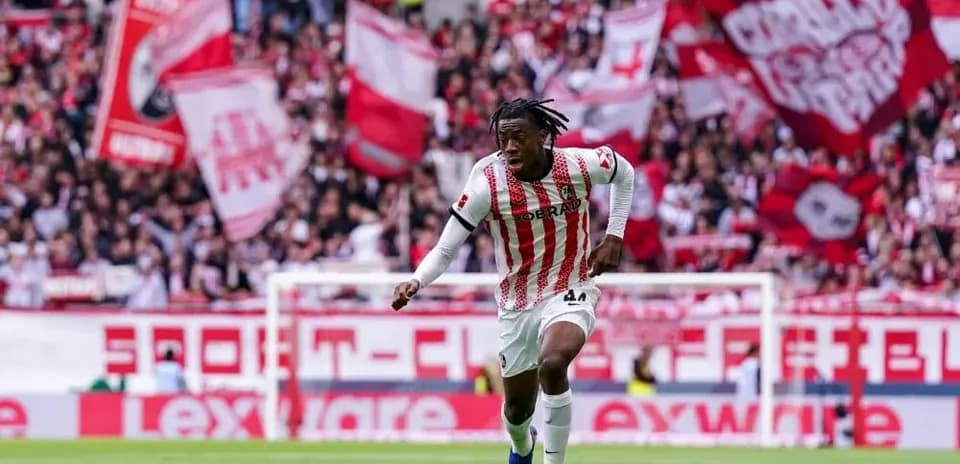 Jugador corriendo con el balón en el estadio