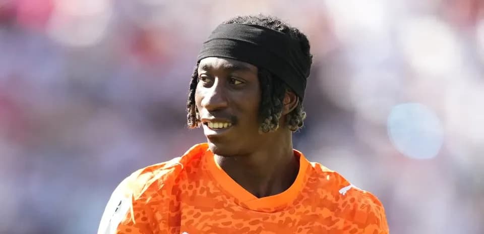 Portero de fútbol con camiseta naranja en el campo
