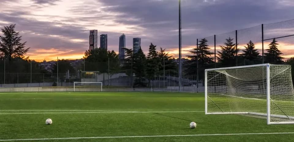 Campo de fútbol al atardecer con dos balones
