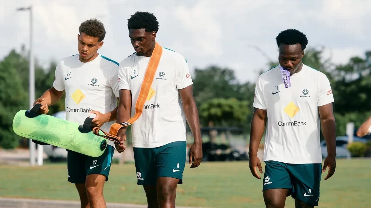 Tres jugadores de fútbol caminando en sesión de entrenamiento