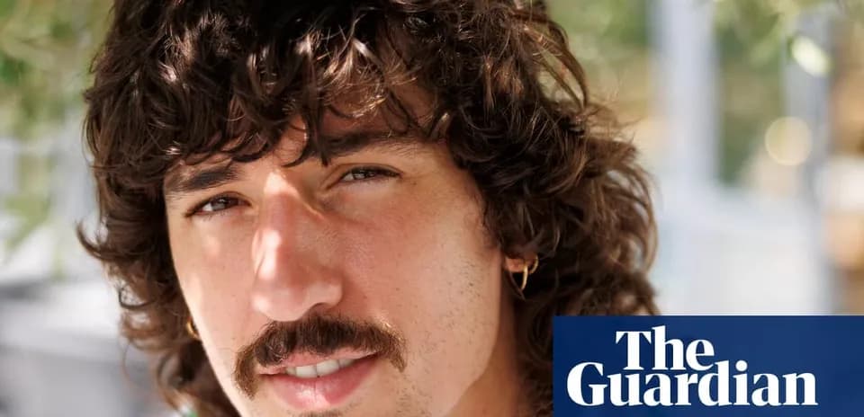 Hombre con cabello rizado y bigote en exterior