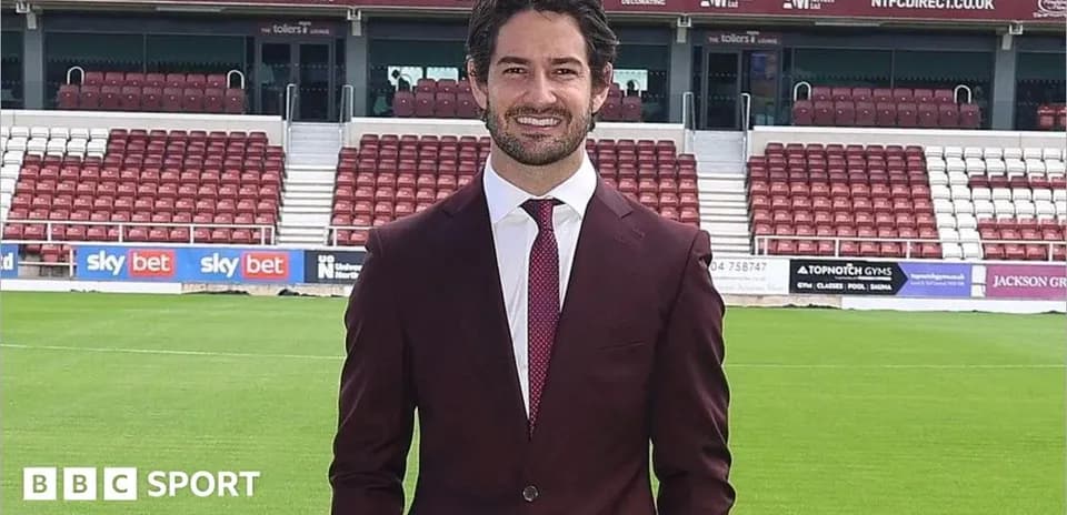 Persona posando en campo de fútbol con traje