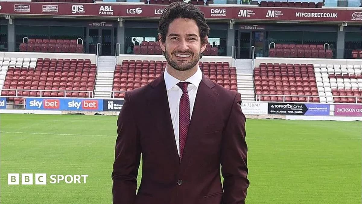 Persona posando en campo de fútbol con traje