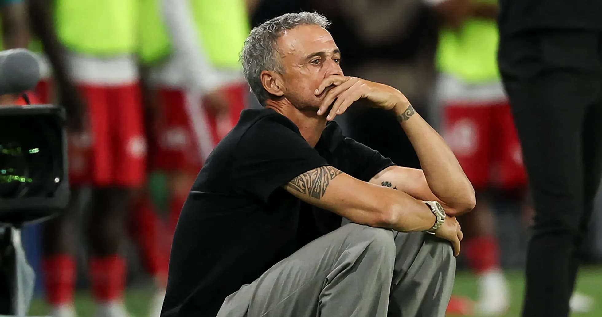 Entrenador sentado durante el partido, pensativo
