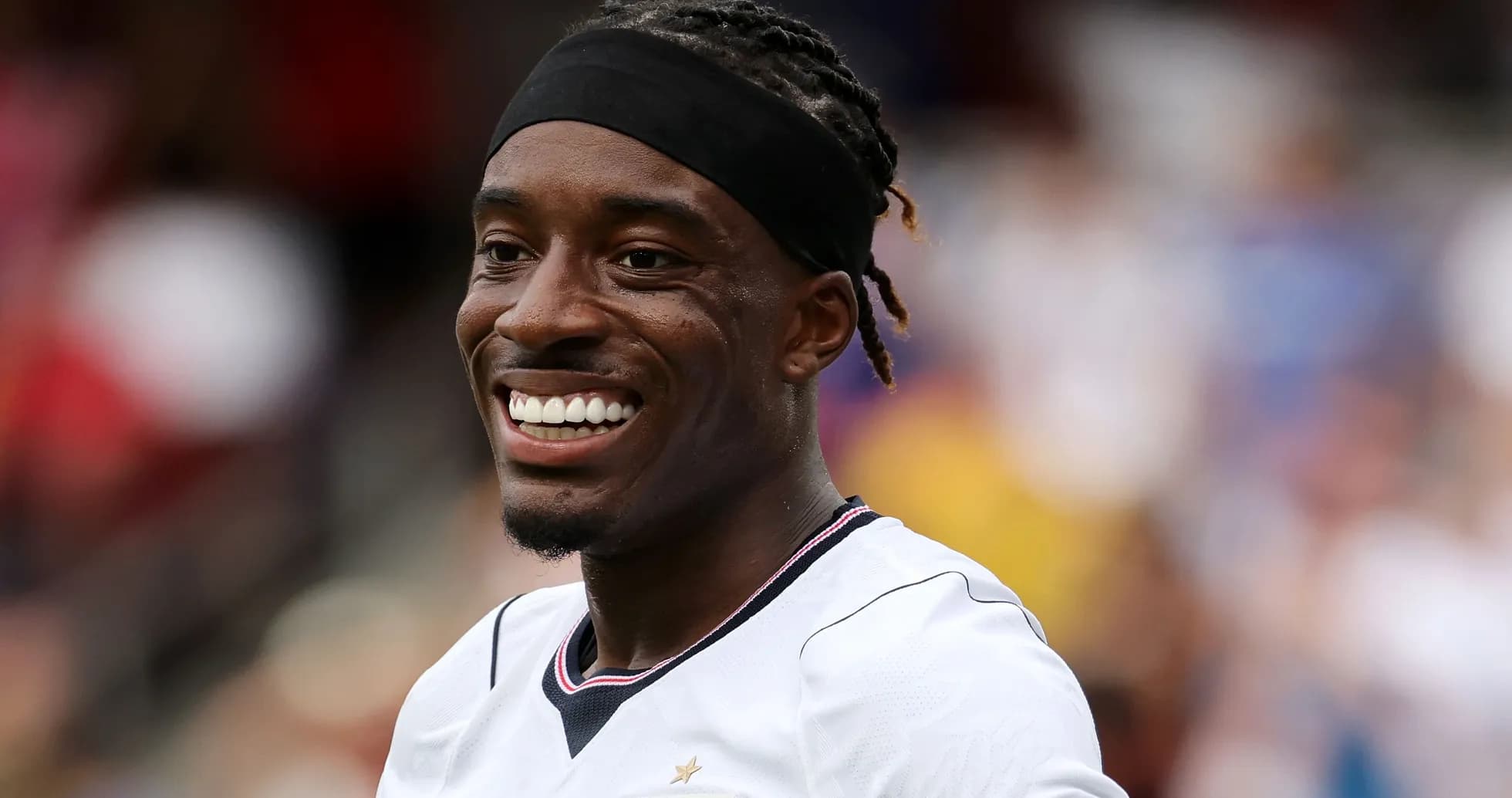 Jugador sonriendo en uniforme de fútbol durante el partido