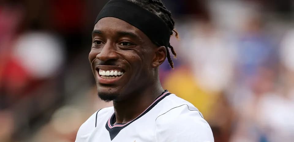 Jugador sonriendo en uniforme de fútbol durante el partido
