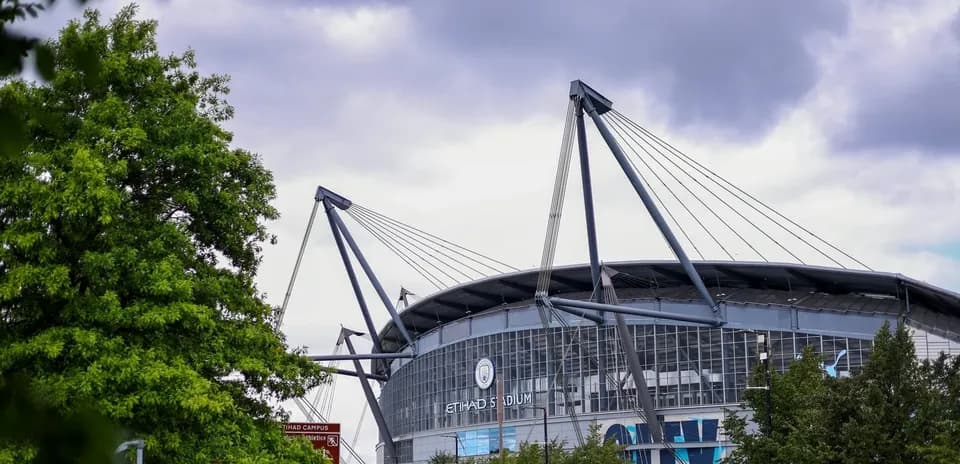 Vista exterior del Etihad Stadium entre árboles