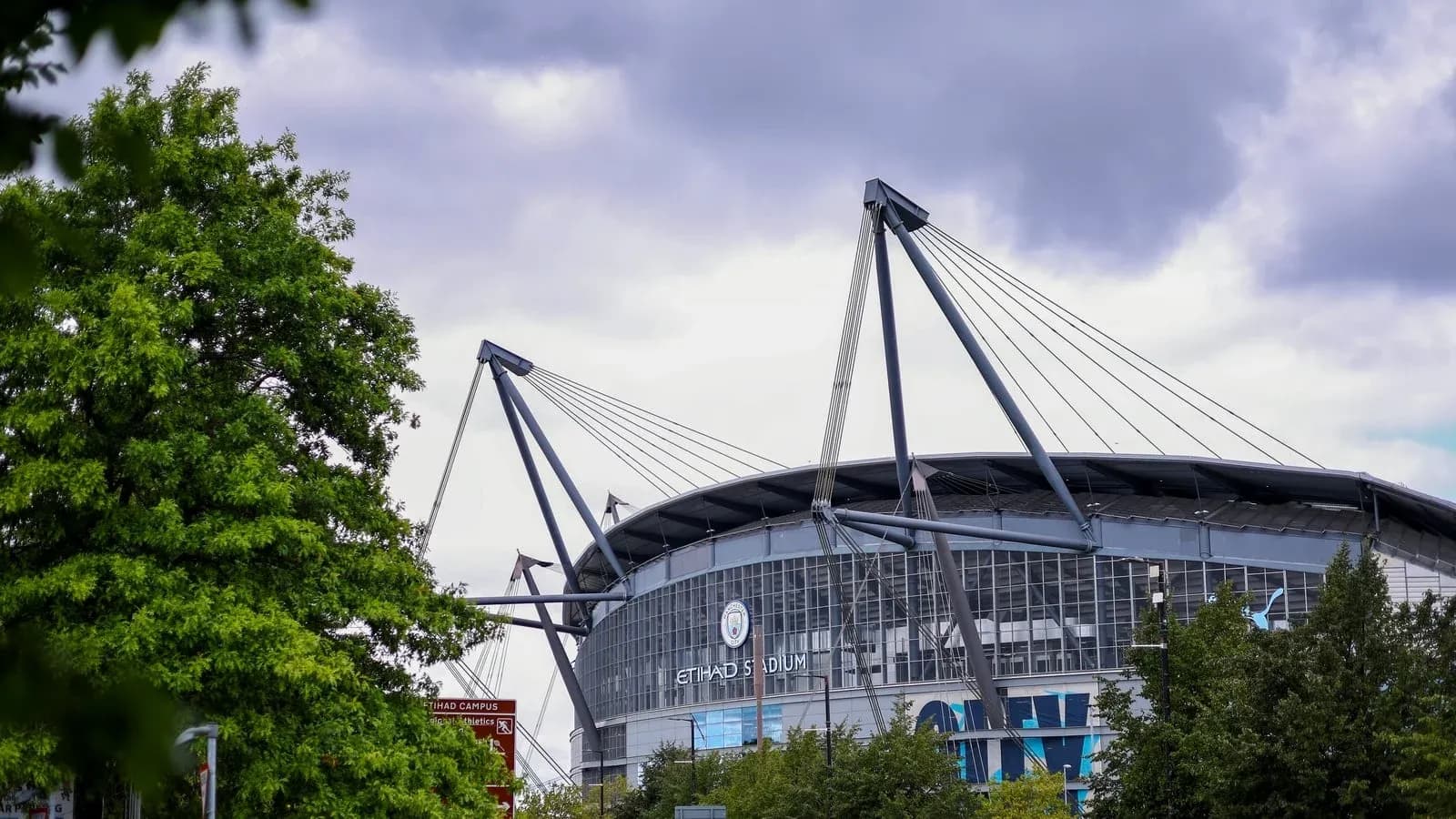 Vista exterior del Etihad Stadium entre árboles