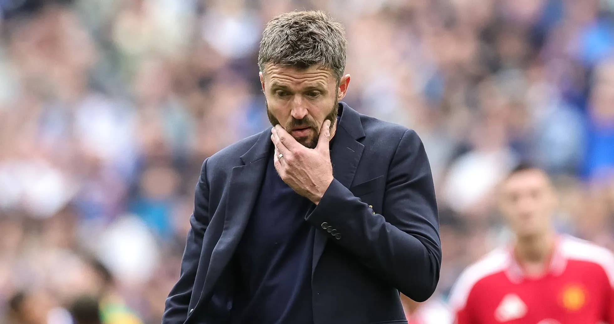 Entrenador pensando durante un partido de fútbol