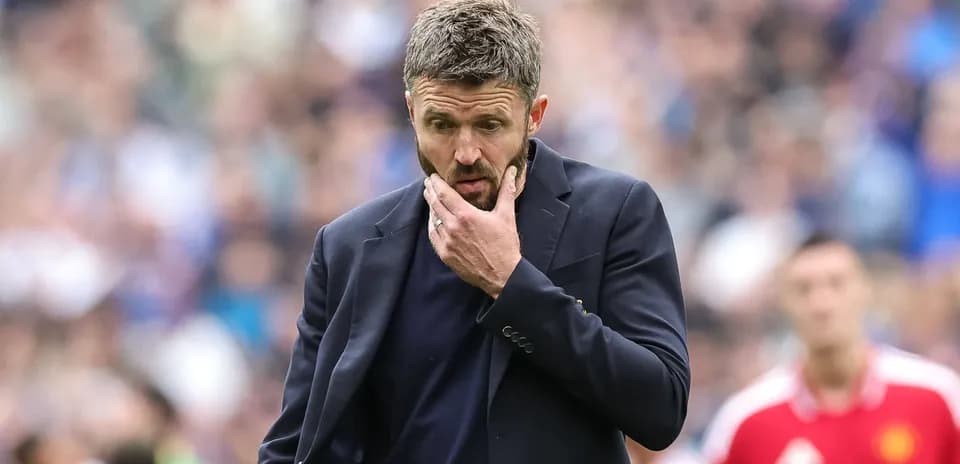 Entrenador pensando durante un partido de fútbol