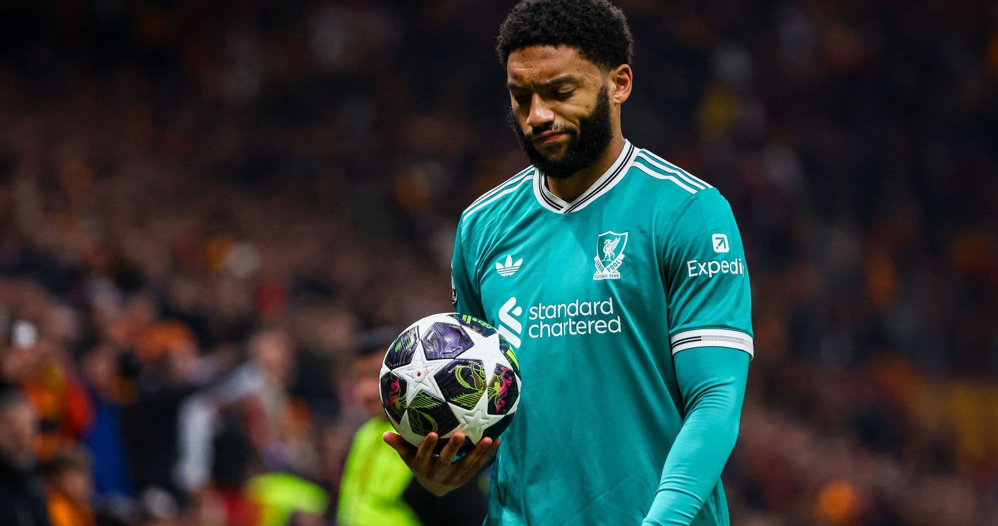 Jugador de Liverpool sosteniendo un balón en el campo