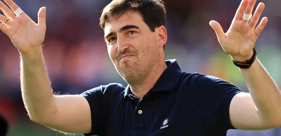 Entrenador saludando al público en el estadio
