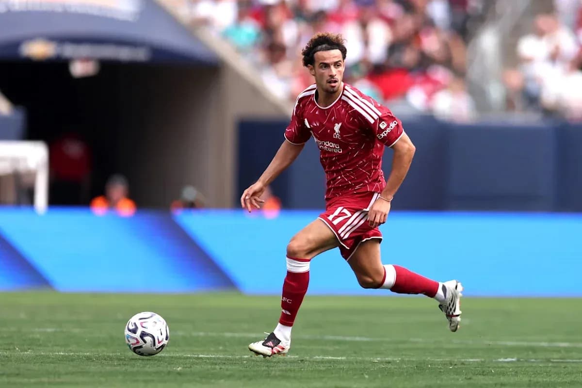 Jugador de Liverpool corriendo con el balón en campo