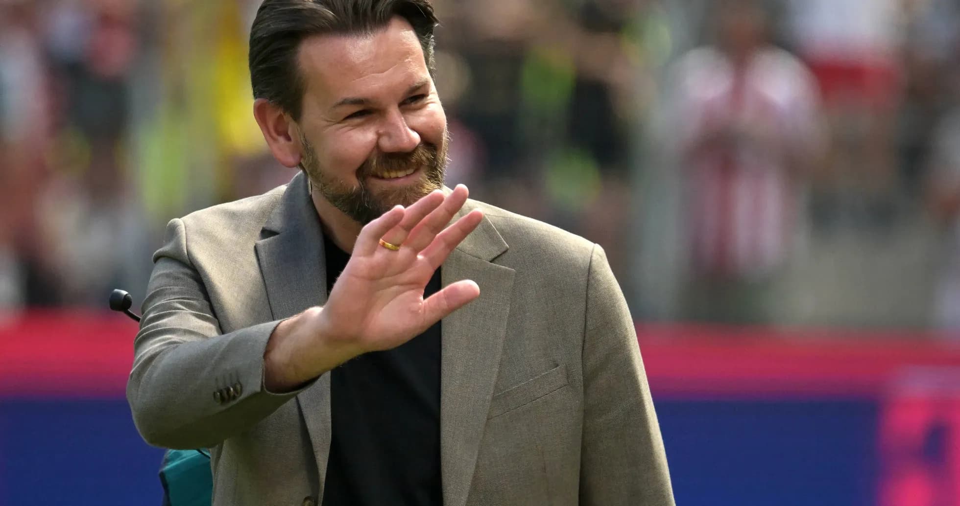 Hombre saludando en el campo de fútbol