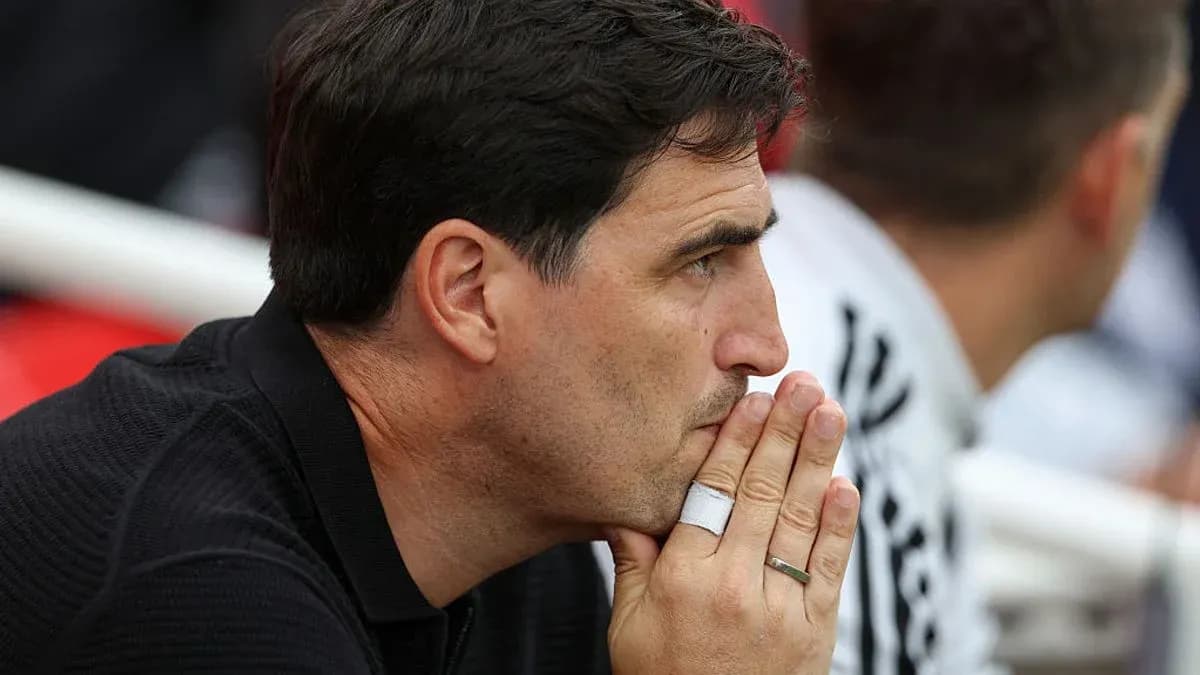 Entrenador observando el partido con expresión pensativa