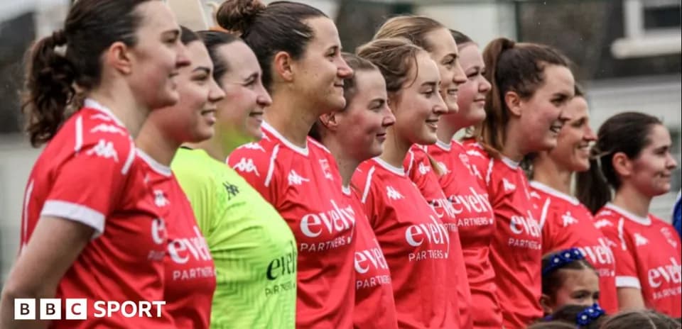 Equipo femenino posando en uniforme rojo en el campo