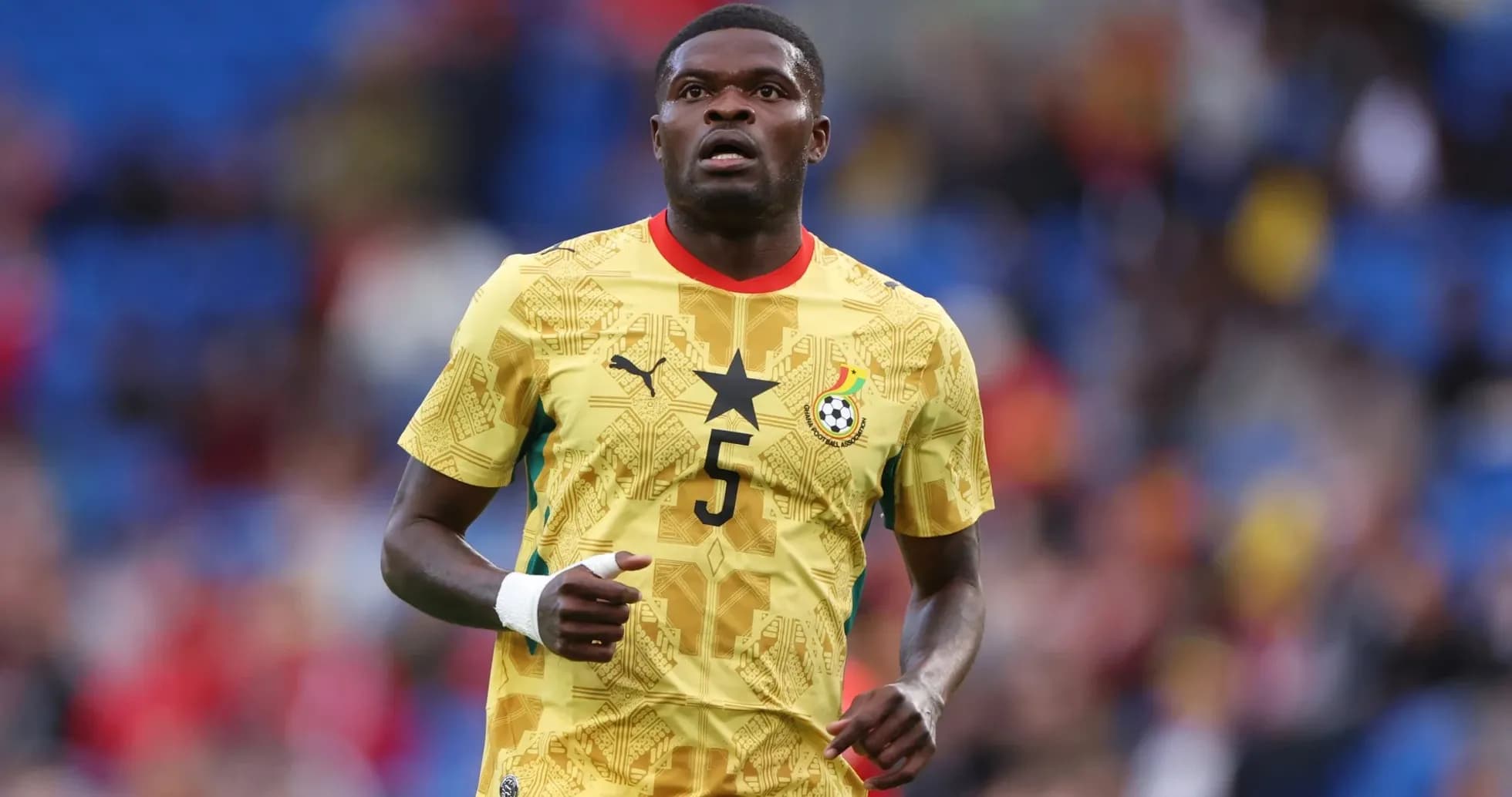 Jugador de Ghana con camiseta amarilla en el campo