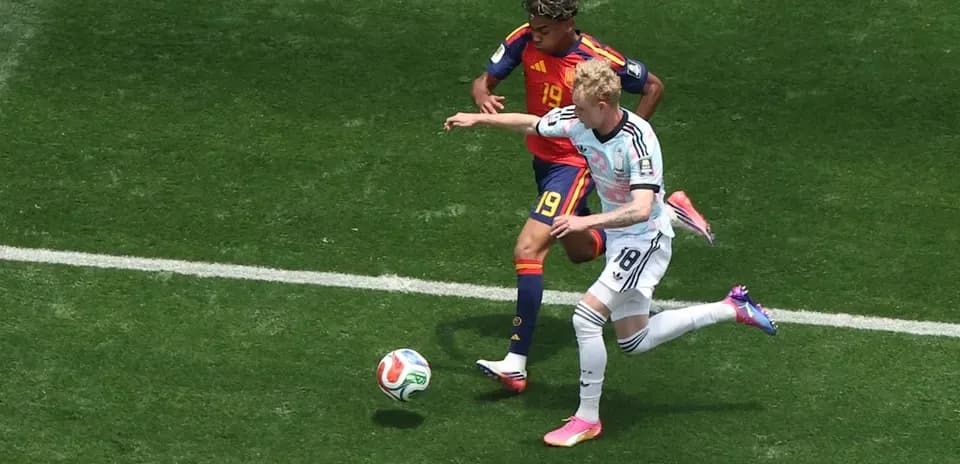 Jugador de Alemania intenta recuperar el balón de España