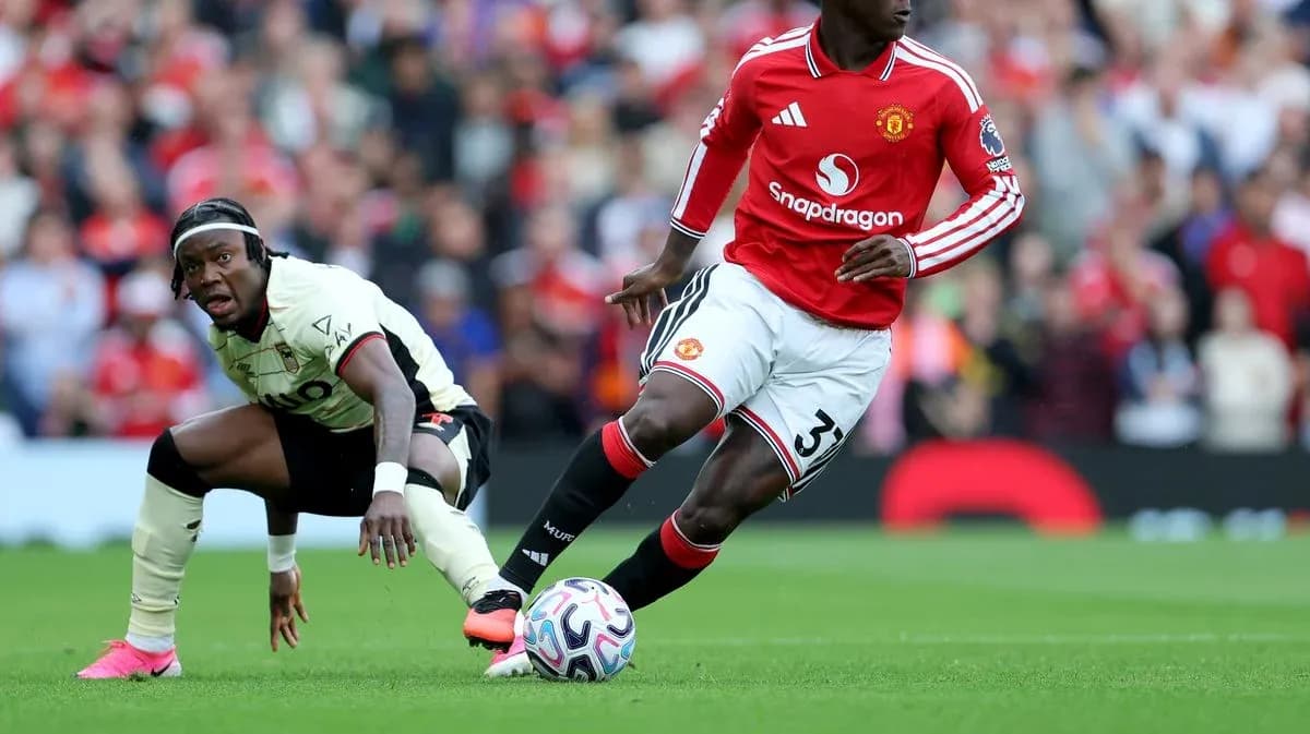 Jugador de Manchester United driblando mientras oponente cae