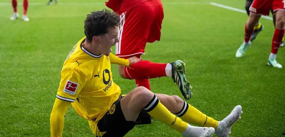 Jugador de Borussia Dortmund cae tras un tackle