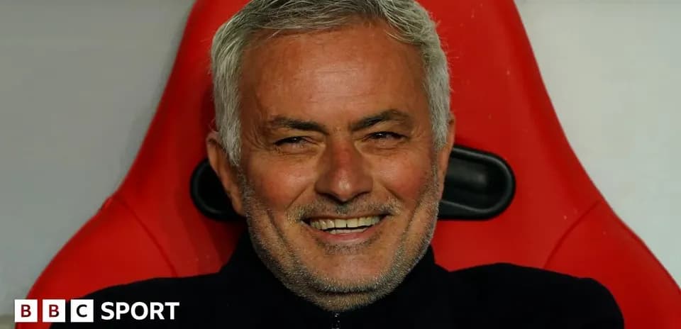 Entrenador sonriendo en el banquillo de su equipo
